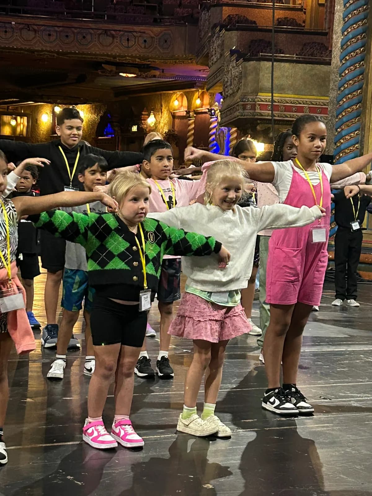 Close-up of campers dancing with arms outstretched onstage
