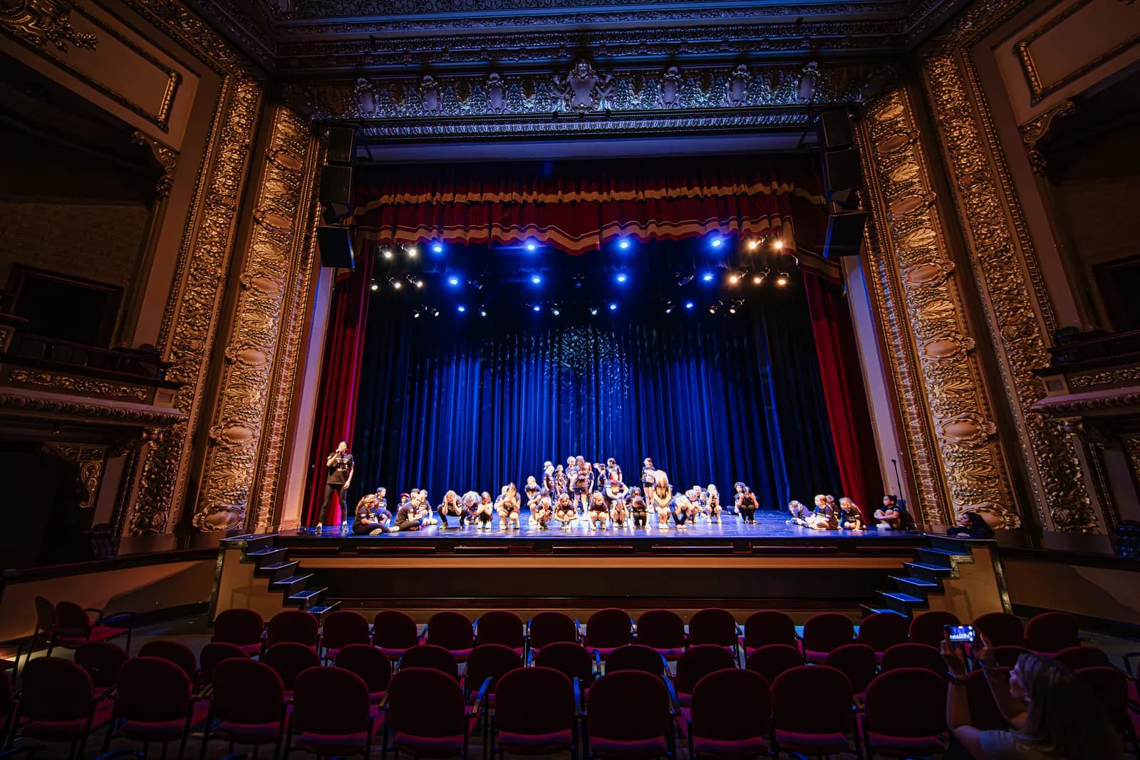 Campers holding a final pose onstage in an ornate theatre