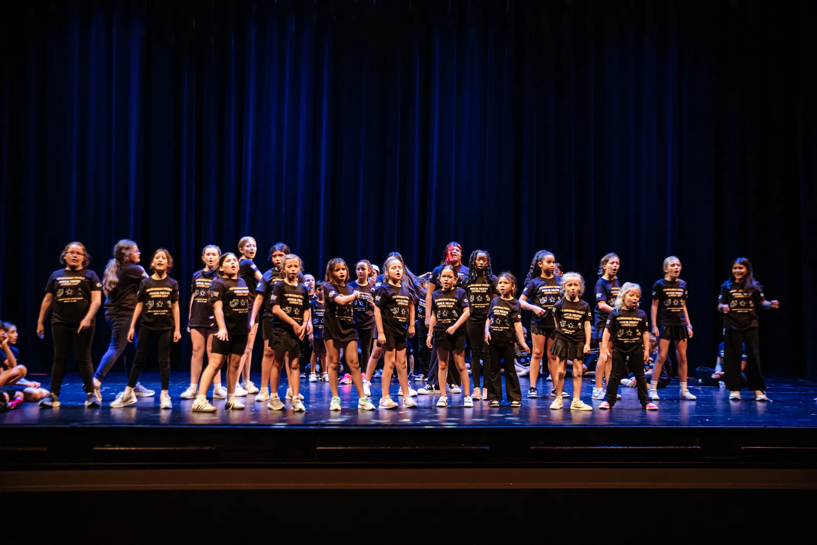 Campers standing together onstage in camp T-shirts
