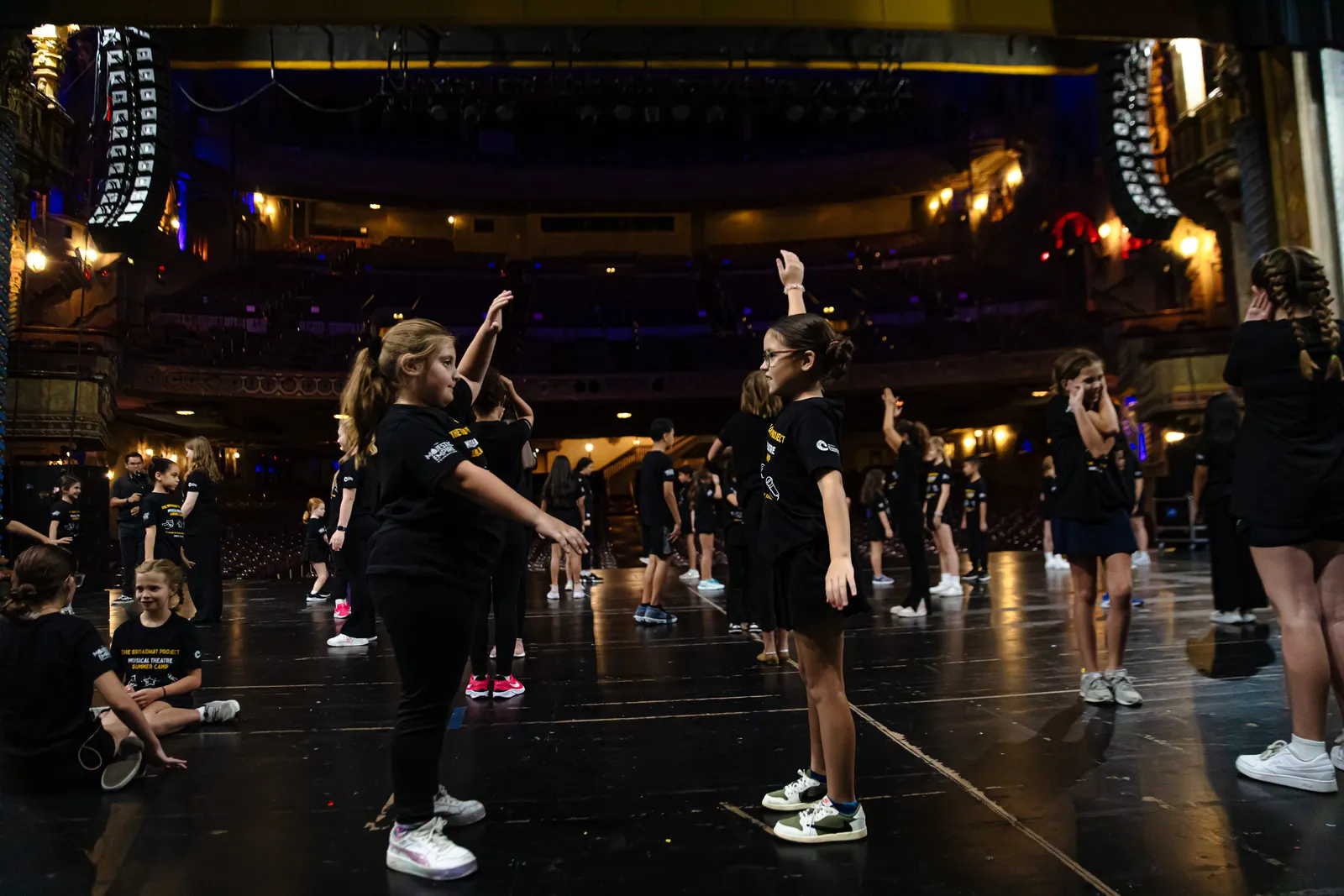 Campers rehearsing onstage in an ornate historic theatre