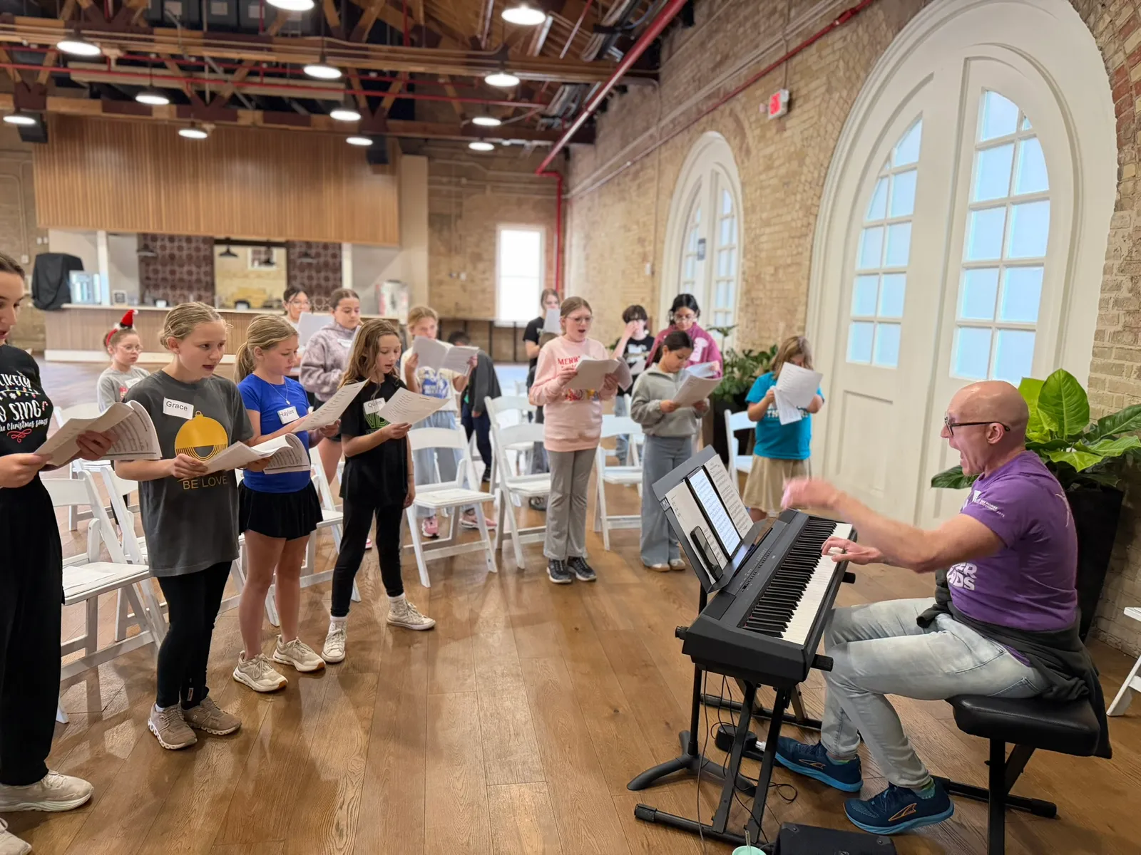 Campers gathered around a pianist for a singing rehearsal